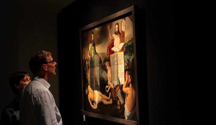 Bezoekers kijken naar schilderij